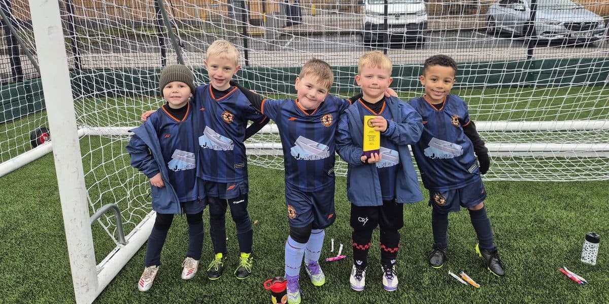 Young football players celebrating victory at Rushall Village FC.